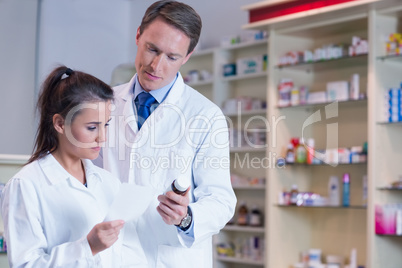 Pharmacist showing medication to his trainee