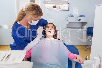 Pediatric dentist examining her young patient