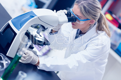 Science student looking through microscope in the lab