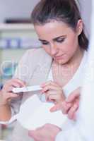 Young woman reading pregnancy test