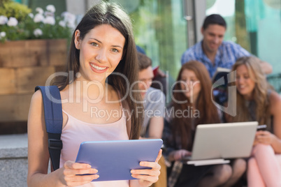 Pretty student using her tablet pc on campus