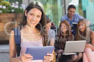 Pretty student using her tablet pc on campus