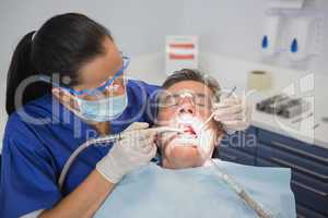 Dentist examining a patient with tools and light