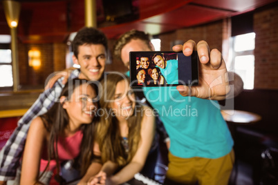 Portrait of happy friends taking a photo with a phone