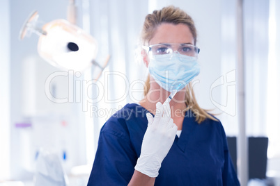 Dentist in mask and glove holding an injection