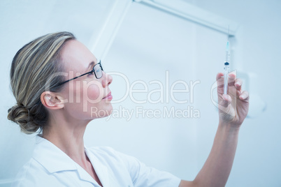 Female dentist holding injection