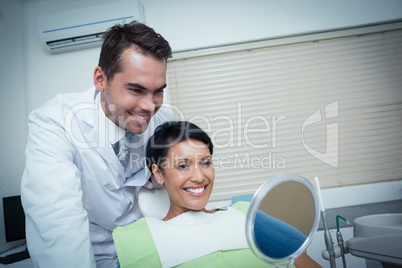 Smiling young woman looking at mirror