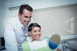 Smiling young woman looking at mirror