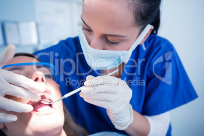 Dentist examining a patients teeth under bright light