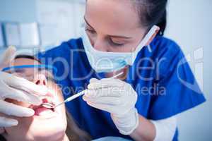 Dentist examining a patients teeth under bright light