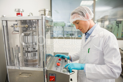 Pharmacist using machinery to make medicine