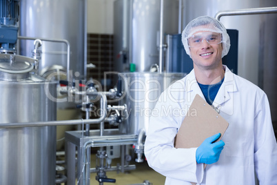 Smiling scientist looking at camera holding a clipboard