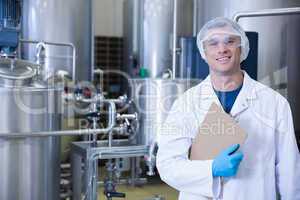 Smiling scientist looking at camera holding a clipboard