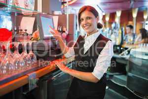 Happy barmaid using touchscreen till