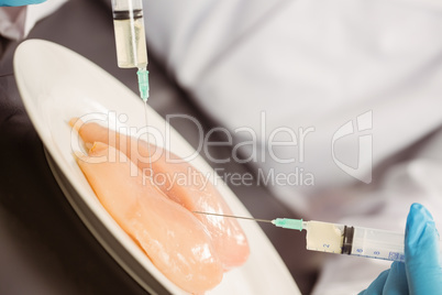 Food scientist injecting raw chicken