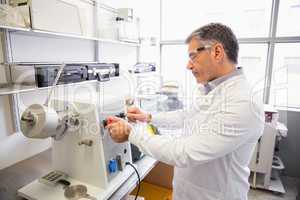 Senior pharmacist using machine to make medicine
