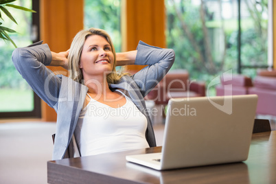 Blonde businesswoman smiling using laptop