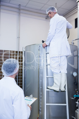 Colleagues speaking while on standing on the ladder