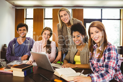 Student smiling at the camera with their teacher