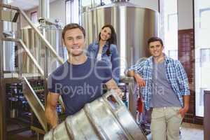 Young man holding keg with these colleagues behind him