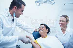 Male dentist shaking hands with woman