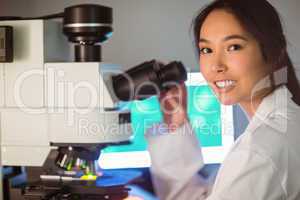 Science student looking through microscope