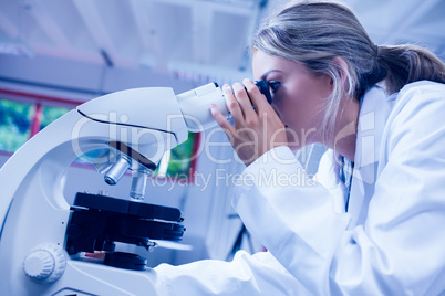 Science student looking through microscope in the lab