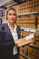 Woman reading a book from shelf standing