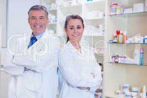 Pharmacist with his trainee standing with arms crossed