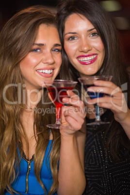 Pretty friends drinking cocktails together