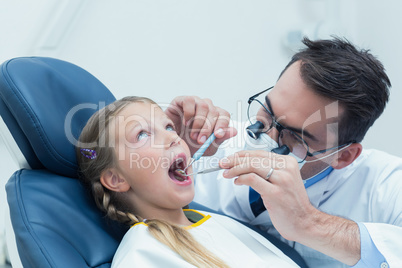 Male dentist examining girls teeth