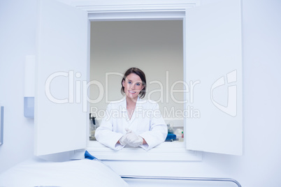 Female biologist smiling at the camera out the window