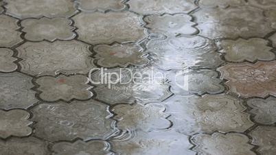 Rain water drops falling on the pavement