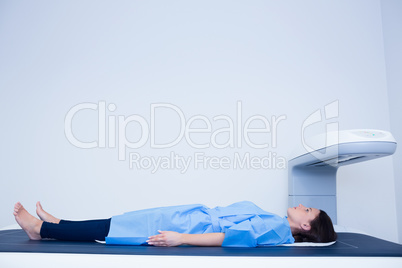 Sick woman lying on a x-ray machine