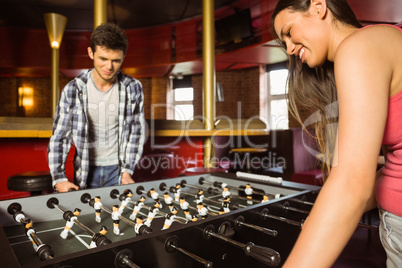 Smiling friends playing table football