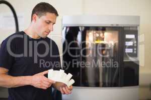 Engineering student holding object printed from 3d printer