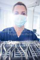 Dentist in blue scrubs showing tray of tools