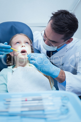 Male dentist examining girls teeth