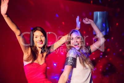 Pretty friends dancing and smiling