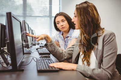 Serious businesswomen looking at computer screen together