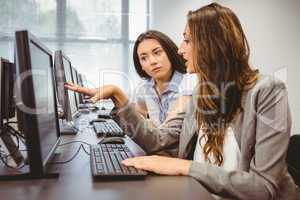 Serious businesswomen looking at computer screen together