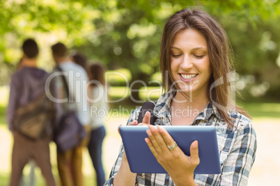 Portrait of a smiling student with a shoulder bag and using tabl