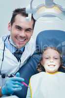 Male dentist examining girls teeth