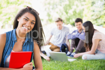 Happy students sitting outside on campus