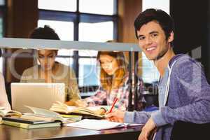 Student looking at camera with his classmates behind him