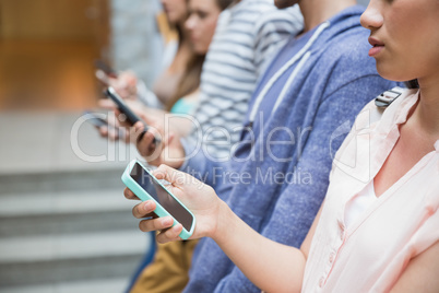 Students using their smartphones in a row