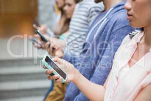 Students using their smartphones in a row