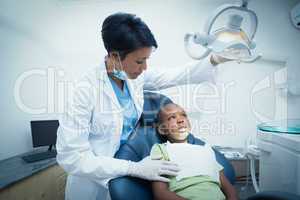 Female dentist examining boys teeth