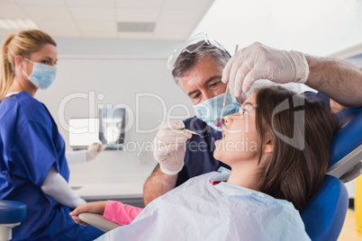 Pediatric dentist examining her young patient