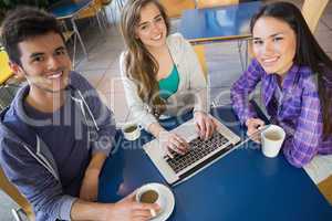 Young students doing assignment on laptop together